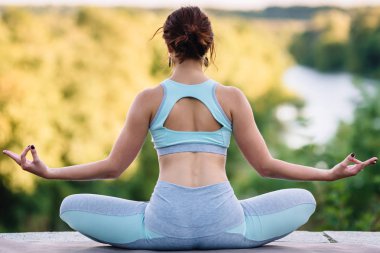 Parkta yoga egzersizi yapan güzel bir kadın.