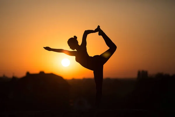 Mulher magro fazendo ioga sobre o sol laranja — Fotografia de Stock