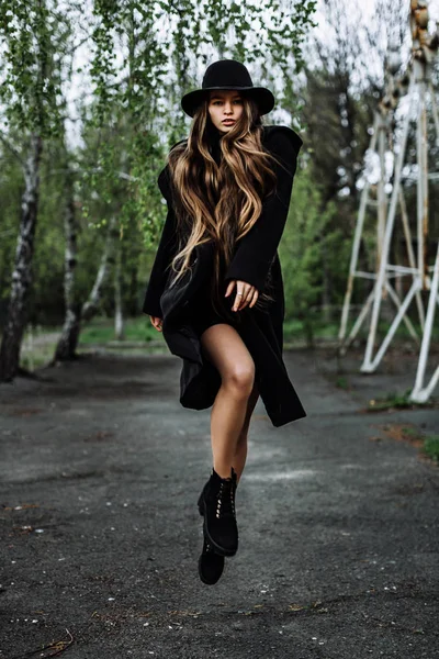 Young beautiful fashionable woman in hat levitate, long hair — Stock Photo, Image