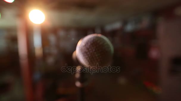 Pohled na mikrofon na scéně čelí prázdné posluchárně. Barevné světelné kužele — Stock video