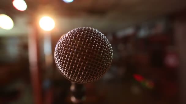 Vista do microfone no palco em frente ao auditório vazio. Holofotes coloridos — Vídeo de Stock