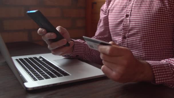 Pengusaha dalam kemeja kotak-kotak melakukan pembayaran online dengan kartu kredit dan smartphone, belanja online — Stok Video