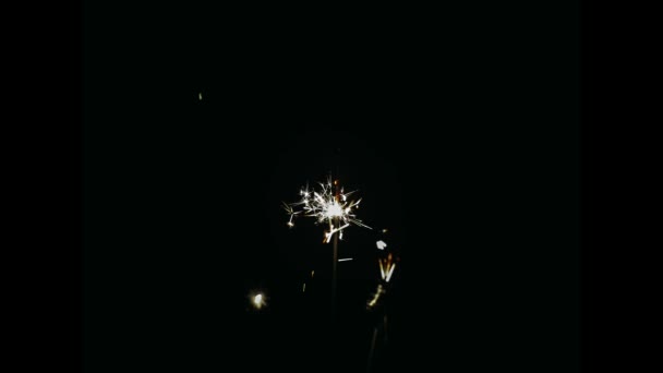 Sparkler tűzijáték égő ellen fekete háttér. Különleges ünnepség, születésnap, karácsonyi koncepciók. Stop motion hatás. — Stock videók