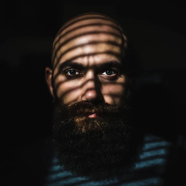 Close-up portrait of middle aged brutal bearded man with expressive eyes and striped shadows on his face — Stock Photo, Image