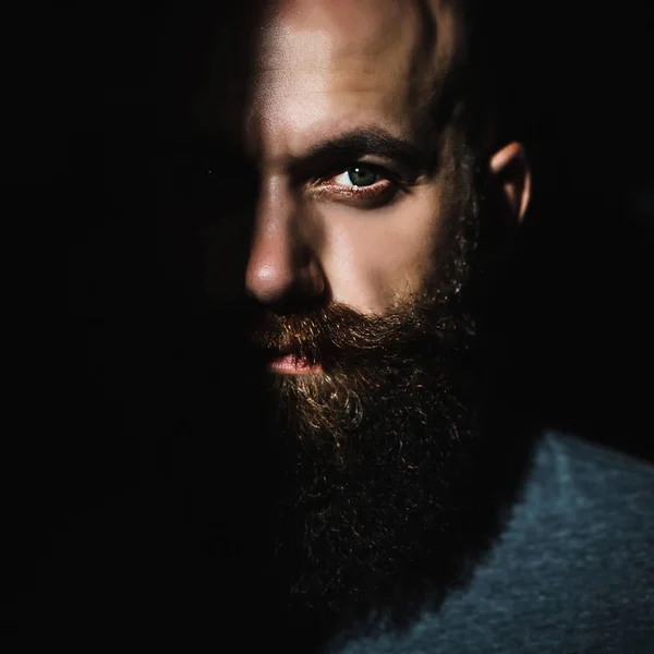 Retrato de cerca del hombre barbudo brutal de mediana edad con ojos expresivos y sombra en la mitad de su rostro — Foto de Stock