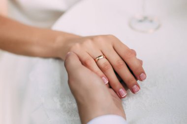 Damat parmağında yüzükle gelinin elini tutuyor.