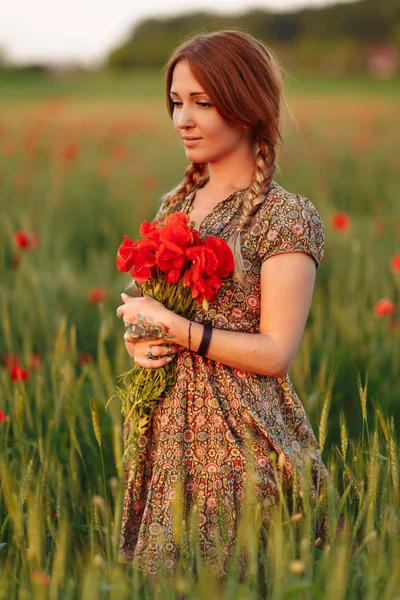 Retrato de mujer pelirroja hermosa en el campo verde con ramo de amapolas —  Fotos de Stock