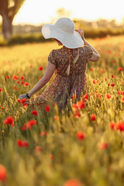 Femme rousse en chapeau sur le champ vert avec des coquelicots — Photo