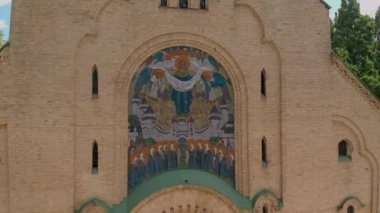 Ukrayna 'nın bulutlu yaz gününde küçük kilisenin tepesine bir dron uçar.