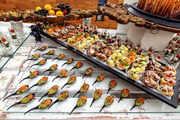 Diferentes snacks en bandeja de madera cerca del bar — Foto de Stock