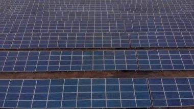 Hava aracı bir güneş çiftliğindeki büyük güneş panellerine doğru bakıyor. Güneş pili santralleri. görüntüler 4k.