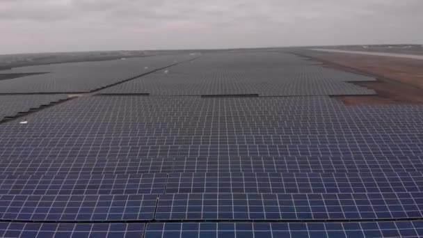 秋の曇りの日に太陽光発電所の大きな太陽光パネルを見下ろす空中ドローンの眺め 太陽電池発電所 映像ビデオ4K — ストック動画