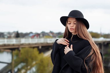 Siyah şapkalı, uzun saçlı, güzel, modaya uygun bir kadın. Kadın modası, güzellik konsepti. Açık hava..