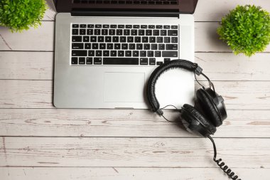 Not defteri maketi ve ofis ahşap masası, defter, kulaklık ve bitki. Masa maketi ve üst görünüm minimalist tasarımı.