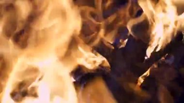 4K gece yanan ağaçların yakın plan çekimi. Şenlik ateşi parlak, ısı, ışık, kamp ateşi, büyük şenlik ateşi, kamp ateşi, yanan odun, turuncu ateş ve duman.