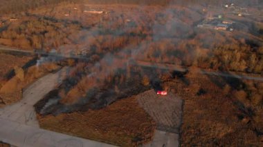 İtfaiyeciler, yanan sarı kuru otları söndürüyor. 4K hava atışı