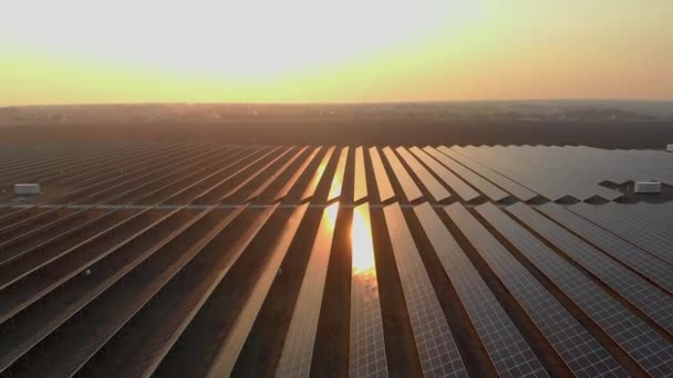 Blick aus der Luft in große Sonnenkollektoren eines Solarparks bei Sonnenuntergang. Solarzellenanlagen. Videomaterial 4k. — Stockvideo