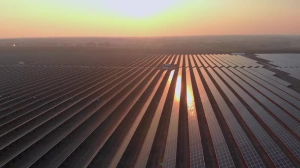 Vista aérea do drone em painéis solares grandes em uma fazenda solar no por do sol brilhante. Centrais de energia solar. imagens de vídeo 4k. — Vídeo de Stock