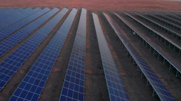Αεροφωτογραφία drone σε μεγάλους ηλιακούς συλλέκτες σε ένα ηλιακό αγρόκτημα στις αρχές της άνοιξης ηλιοβασίλεμα. Μονάδες παραγωγής ηλεκτρικής ενέργειας ηλιακών κυττάρων. βίντεο 4k. — Αρχείο Βίντεο