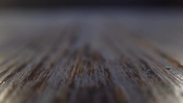 Stack of euro coins falling down on wooden background. Closeup view and soft focus, slow motion — Stock Video