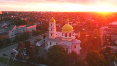 Parlak bulutlu günbatımında küçük bir kilise. Küçük Avrupa şehrinde dron tarafından çekiliyor. Kyiv bölgesi, Ukrayna.