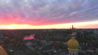 Parlak bulutlu günbatımında küçük bir kilise. Küçük Avrupa şehrinde dron tarafından çekiliyor. Kyiv bölgesi, Ukrayna.