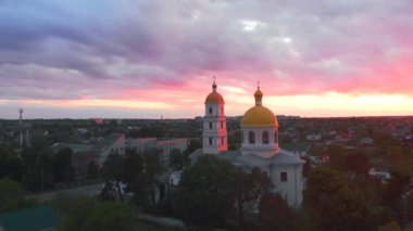 Parlak bulutlu günbatımında küçük bir kilise. Küçük Avrupa şehrinde dron tarafından çekiliyor. Kyiv bölgesi, Ukrayna.