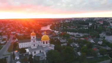 Parlak bulutlu günbatımında küçük bir kilise. Küçük Avrupa şehrinde dron tarafından çekiliyor. Kyiv bölgesi, Ukrayna.