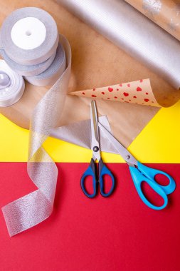 Hediye ambalaj kutuları, kağıt, şerit ve makas renk arka plan üzerinde. Malzemeler aksesuarlar sunar. Yakın çekim.