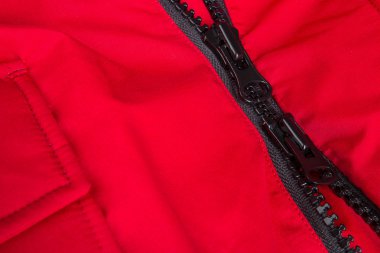 Siyah fermuarlı kırmızı bir ceket parçası. Fermuarlı arka plan. Kapat..