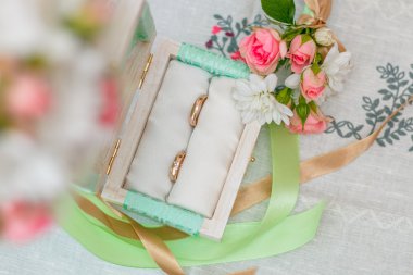 Buket çiçek beyaz masa örtüsü üzerinde yakınındaki alyans. Üstten Görünüm