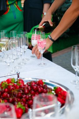 Resepsiyon Masa. Bardağı içinde dökün. Şarap, şampanya, tabak ve çilek beyaz masa örtüsü üzerinde bardak. Catering iş.