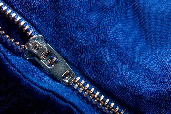 Θραύσμα του μπλε μπουφάν με φερμουάρ μέταλλο, φερμουάρ. ziplock φόντο. Κοντινό πλάνο. — Φωτογραφία Αρχείου