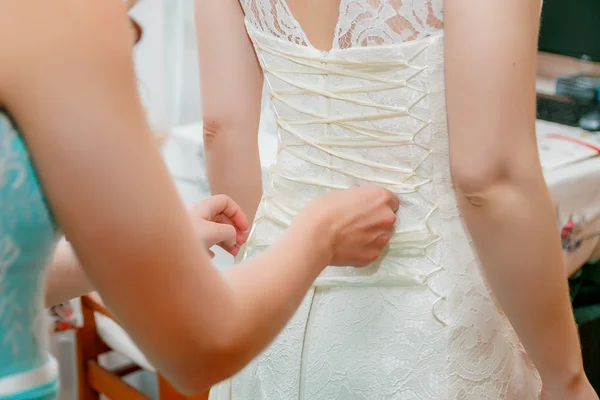 A abotoar o vestido de noiva da noiva. Fechar . — Fotografia de Stock