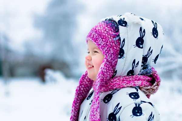 Enfant par temps neigeux. Bébé fille en suite blanche et rose hatin le parc d'hiver de neige. Heureux. Souriez. . — Photo