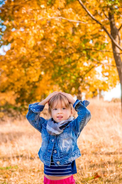 Bambina con foglie d'oro giallo autunno. Bambino giocare all'aperto nel parco . — Foto Stock
