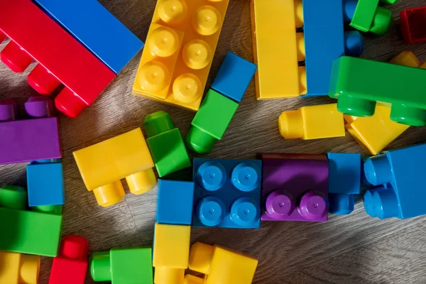 Ahşap arka plan gri parlak plastik inşaat blok. Oyuncaklar geliştirilmesi. Erken öğrenme. Çerçeve. Üstten Görünüm.