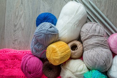 Örgü. Grup iplik ve gri ahşap masa iğne falan batmazdı. El yapımı. Yakın çekim. Üstten Görünüm. Kopya alanı.