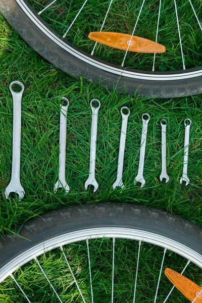ซ่อมจักรยาน เครื่องมือสําหรับซ่อมจักรยานบนหญ้าระหว่างล้อ . — ภาพถ่ายสต็อก