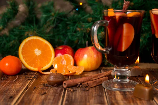 Ζεστό κρασί με φρούτα και μπαχαρικά σε ξύλινο τραπέζι. Διακοσμήσεις Χριστουγέννων στο υπόβαθρο. Χειμώνα του πλανήτη ποτό συνταγή συστατικά στη γύρω περιοχή. — Φωτογραφία Αρχείου