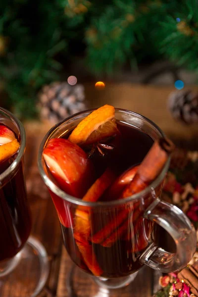 Κοντινό πλάνο, Χριστουγεννιάτικο ζεστό κρασί με φρούτα και μπαχαρικά σε ξύλινο τραπέζι. Χριστούγεννα διακοσμήσεις στο παρασκήνιο. Χειμώνα του πλανήτη ποτό φρούτων συστατικά γύρω από. — Φωτογραφία Αρχείου