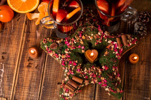 Stella di Natale vicino al vin brulè con frutta e spezie sul tavolo di legno. Decorazioni natalizie sullo sfondo. Due bicchieri. Ricetta bevanda riscaldante invernale ingredienti intorno. vista dall'alto . — Foto Stock