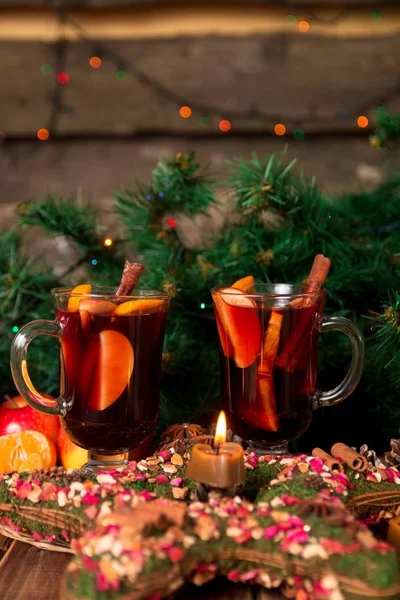 크리스마스 mulled 와인 과일 및 향미료 나무 테이블에. 백그라운드에서 크리스마스 장식입니다. 2 안경입니다. 레시피 재료 주위를 마시는 겨울 온난. — 스톡 사진