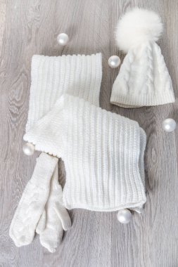 Yeni yıl ağacı topları masada yakınındaki örme soğuk hava aksesuar. Beyaz şapka, atkı karınca gri ahşap arka plan eldiven. Üstten Görünüm. Noel dekorasyon.