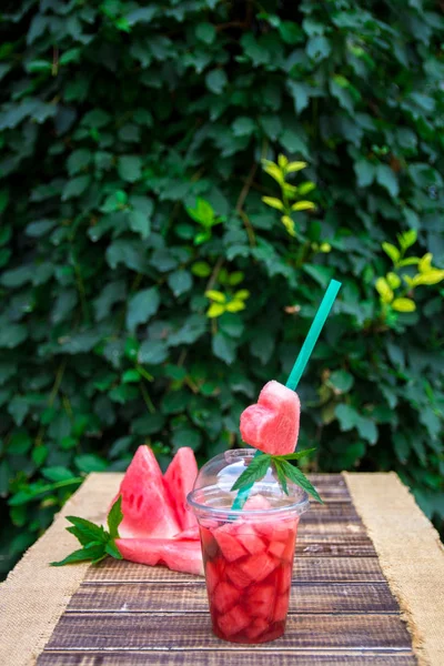 Watermeloen cocktail met schijfje op houten ondergrond, buiten. Hart uit de buis gesneden. — Stockfoto