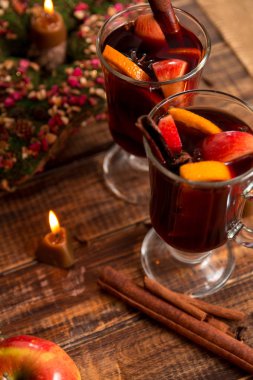 Mum ile meyve ve baharat ahşap masa üzerinde yakınındaki mulled şarap. Noel. Kış ısınma tarifi Malzemeler çevresinde iç. İki fincan, gözlük.