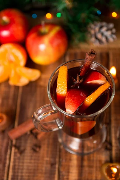 Χριστουγεννιάτικο ζεστό κρασί με φρούτα και μπαχαρικά σε ξύλινο τραπέζι. Χριστούγεννα διακοσμήσεις στο παρασκήνιο. Το χειμώνα του πλανήτη ποτό με συστατικά συνταγή γύρω. Το Top view. — Φωτογραφία Αρχείου