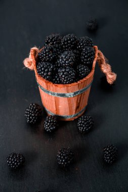 Siyah ahududu ahşap sepet içinde ve masada. Yakın çekim.