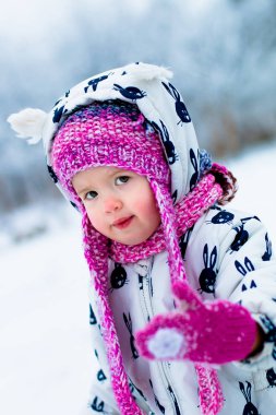 Karlı gün çocuk. Beyaz snowsuite ve pembe şapka, bot eldiven kar kış parkta kız bebek.  