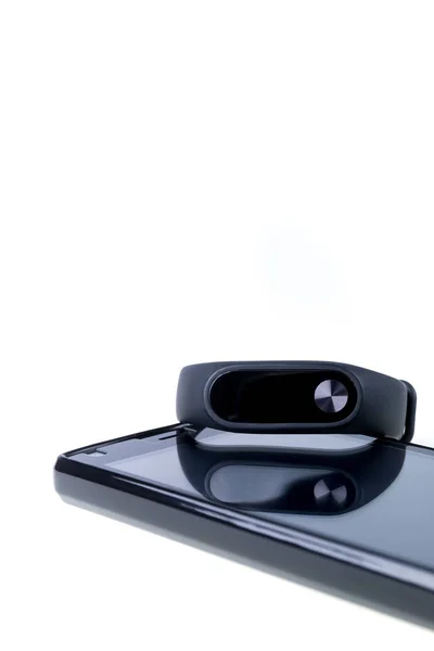Rastreador de fitness negro y smartphone aislado sobre fondo blanco . — Foto de Stock